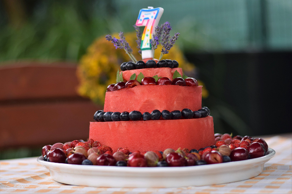 Torta z melóna zdobená ovocím na stole