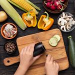 Zelenina na kuchynskej linke, ruky krájajú baklažán