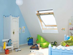 Detská izba s bielou skriňou, modrou posteľou a strešným oknom
