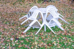 Plastový stôl so stoličkami v záhrade, jeseň