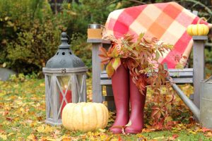 Jesenný aranžmán v záhrade - bordové gumáky, tekvica, svietnik a sedenie s dekou