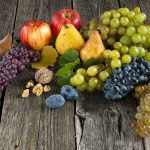 Hrozno, jablká, slivky a hrušky na drevenom podklade