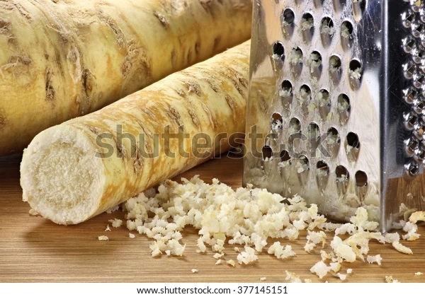 horseradish grater on wooden background 600w 377145151