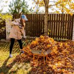 Žena hrabe lístie v záhrade