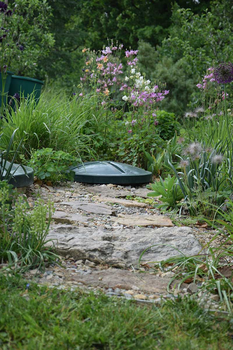 Nášľapné dosky smerujúce k poklopu domácej čističky