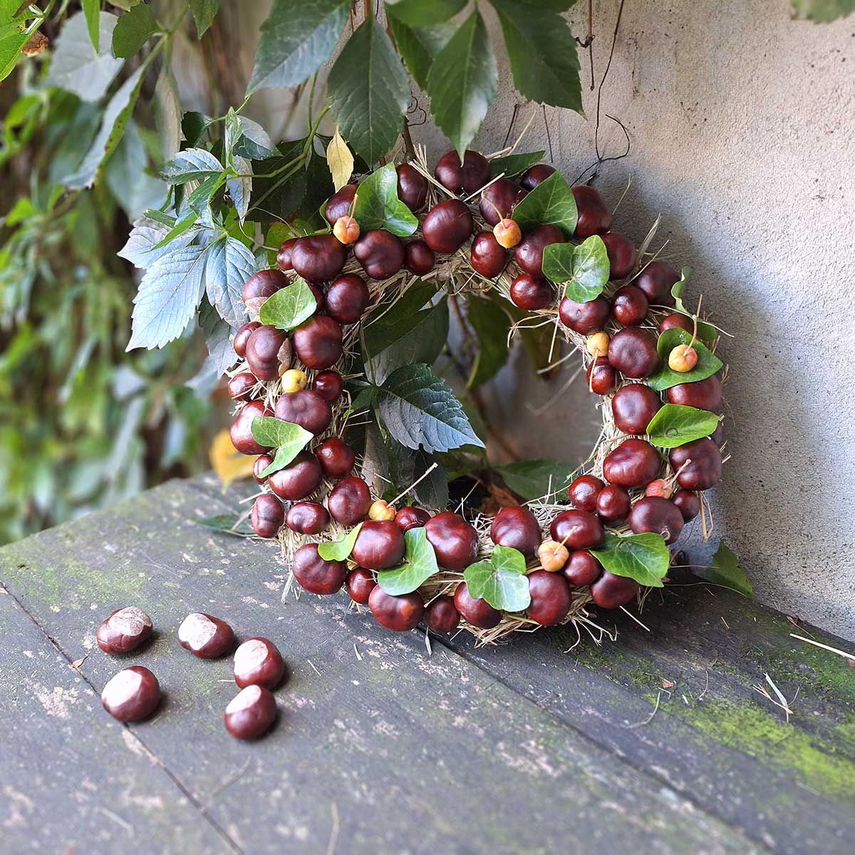Jesenný veniec z konárov, sena, gaštanov a brečtanu