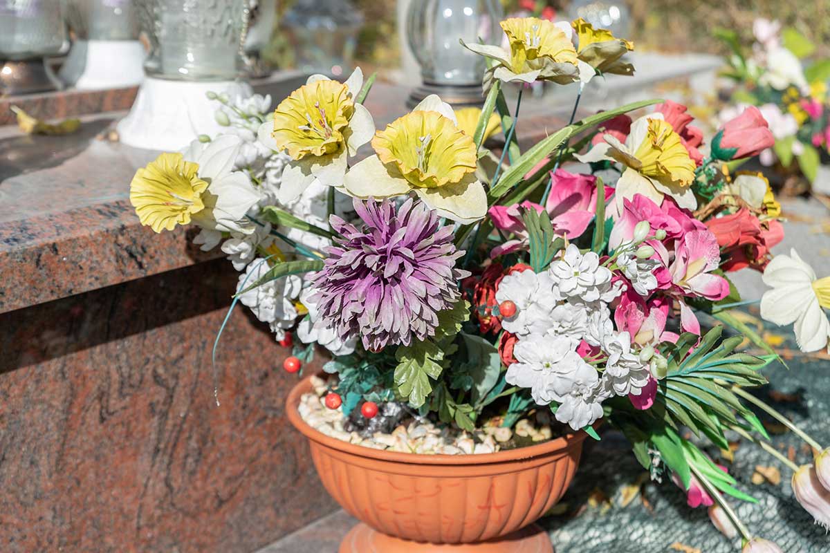 Umelé kvety v kvetináči na hrobe