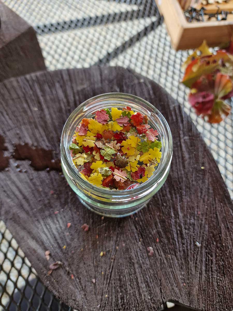 Priliatie vody do pohára s farebnými lístkami