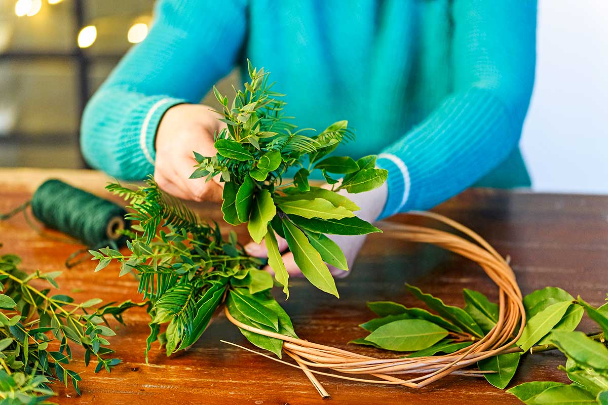 Pridávanie kytičiek zelene do vianočného venca