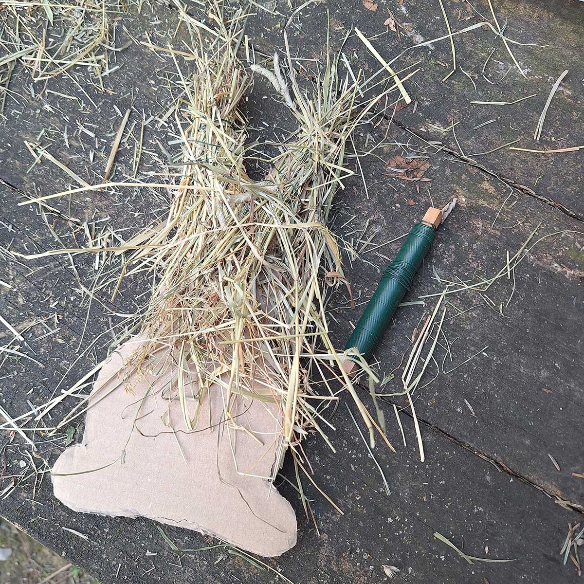 Pripevňovanie sena na kartónový základ pomocou viazacieho drôtu