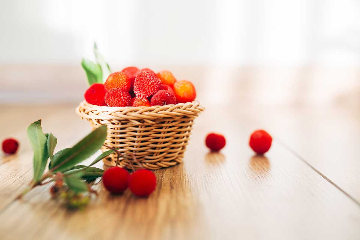 Plody jahodového stromu v košíku